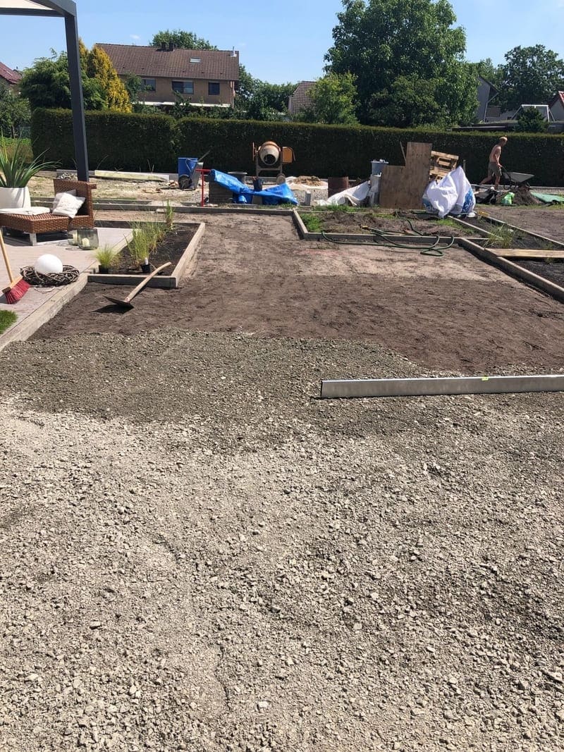 Ein Garten mit Erde und Kies in der Mitte. Vorbereitung für den Kunstrasen Unterbau. (1)(1)